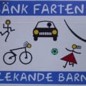 a swedish-language road sign says "sank farten; lekande barn" with drawings of kids playing and cyclists in the road